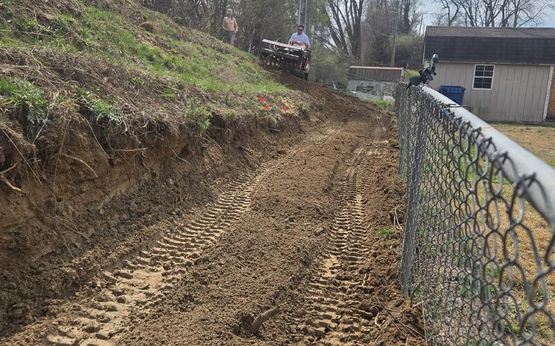 Freshly cleared strip along a fence line after brush removal